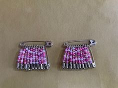 two pairs of pink and white beaded earrings on top of a brown cloth covered table