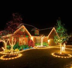 christmas lights decorate the front yard of a house in this suburban neighborhood, which has been decorated with trees and wreaths