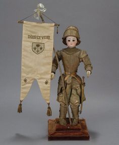 a doll is standing next to a banner on a stand with a flag hanging from it's side