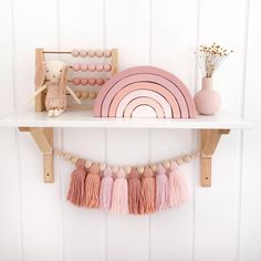 a shelf with some toys on top of it next to a pink and white wall