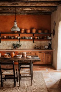 a dining room table and chairs in front of a shelf with pots on the wall