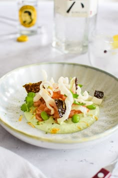 a white plate topped with food next to a bottle of wine