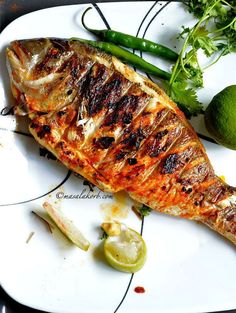 grilled fish and vegetables on a white plate