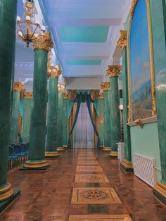 an ornately decorated hallway with green columns and gold trim