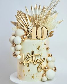 a white cake with gold decorations and the number forty on it