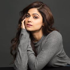 anusha bhatra in grey sweater posing with her hands on her head