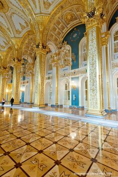 an ornately decorated room with gold and blue walls, chandeliers and marble floors