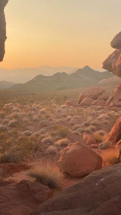 the sun is setting over some rocks in the desert