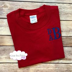 "These monogrammed t-shirts are made of a comfortable cotton fabric, making a casual, yet stylish, addition to the wardrobe of any boy. I offer boys t-shirts using four different styles of fonts. Shirts ordered from this listing will be monogrammed using a stacked font as shown in the listing picture. The order of the letters will be FIRST NAME as the top, small letter, MIDDLE NAME as the bottom small letter, and LAST NAME as the large letter. IMPORTANT: When placing your order please provide th Customizable Cotton T-shirt For School Spirit, School Spirit Cotton Tops With Letter Embroidery, Red Cotton Tops With Name Print, Personalized Red Short Sleeve T-shirt, Personalized Red T-shirt With Short Sleeves, Red Cotton Top With Name Print, Blue Monogram Cotton Tops, Monogrammed Short Sleeve Cotton T-shirt, Personalized School Spirit T-shirt With Crew Neck