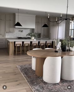 an image of a modern kitchen setting with dining table and stools in the foreground