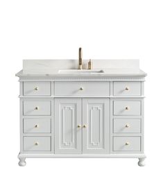 a white bathroom vanity with two sinks and gold faucets on the counter top