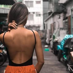 the back of a woman's neck with tattoos on her left shoulder and right arm