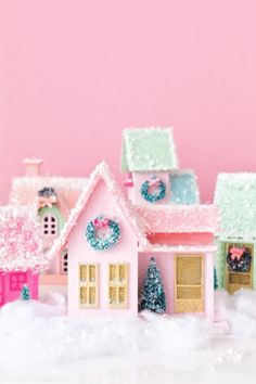 a pink and green toy house with snow on the ground