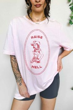 RAISE HELL COUNTRY COWGIRL WESTERN OVERSIZED GRAPHIC TEEPREMIUM COTTONOVERSIZED FIT Pink Screen Print Tops For Streetwear, Trendy Pink Tops With Funny Print, Trendy Pink Top With Funny Print, Pink Cotton Tops With Letter Print, Pink Tops With Funny Print For Streetwear, Pink Funny Print Top For Streetwear, Pink Graphic Tee Cotton Top, Pink Retro Shirt With Relaxed Fit, Relaxed Fit Pink Top With Funny Print