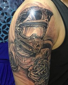 a man with a motorcycle helmet and roses on his arm