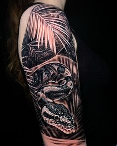 a woman's arm with a black and white tattoo on it, featuring an image of a snake