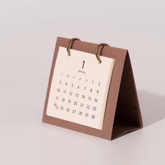 a desk calendar with two rings on the front and one ring on the back that is attached to a clipboard