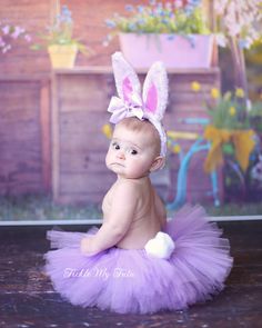 a baby in a purple tutu with an easter bunny ears on it's head