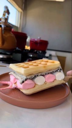 a waffle sandwich with marshmallows and chocolate chips on a brown plate