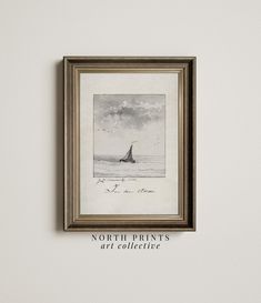 a painting hanging on the wall next to a framed print with an image of a sailboat