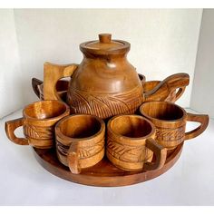 a wooden tray with teapots and cups on it in the shape of a flower