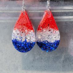 red, white and blue glitter tear earrings hanging from hooks