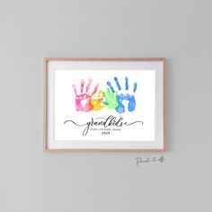 two hand prints with the words grandkids in black and white, hanging on a wall