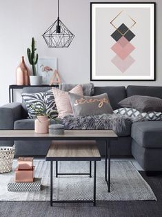 a living room with grey couches and pillows on top of the sofa, coffee table