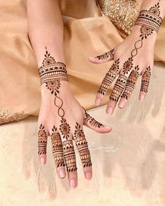 a woman's hands with henna tattoos on them