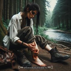 a woman sitting on the ground next to a tree