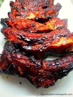 grilled ribs on a white plate covered in bbq sauce