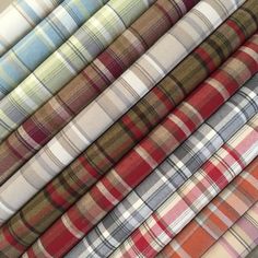 many different plaid fabrics are stacked together