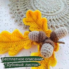 two crocheted acorns are sitting on a doily next to each other