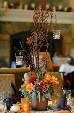 an image of a table setting with flowers and candles on the table in front of a fire place