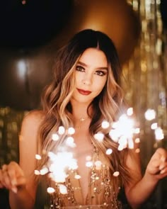 a woman holding sparklers in her hand and looking at the camera with an instagramr