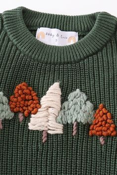 a green sweater with trees on it