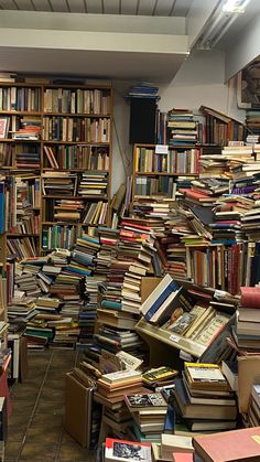 a room filled with lots of books and piles of boxes on top of each other