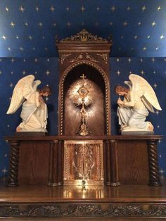 two statues on top of a mantle in a room with blue walls and gold stars