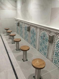 the benches are lined up against the wall in the public restroom, with tiled walls and flooring