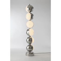 a lamp that is sitting on top of a metal pole with three balls attached to it