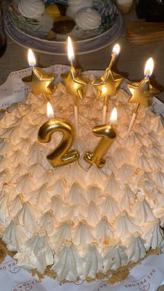 a birthday cake with white frosting and lit candles in the shape of number twenty