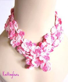 a pink and white crocheted necklace on a mannequin