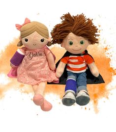 two stuffed dolls sitting next to each other on a white background with orange and pink splots