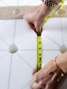 a person measuring the width of a tile floor with a tape measure line on it