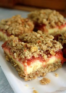 three pieces of dessert sitting on top of a white plate with crumbled toppings