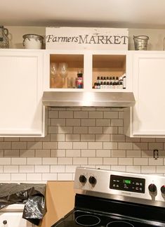 a stove top oven sitting inside of a kitchen next to white cabinets and counter tops