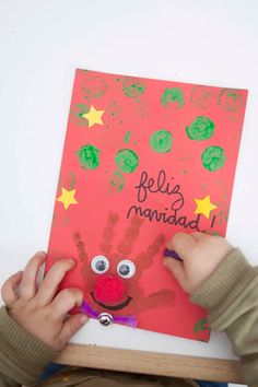 a young child is making a handprinted card