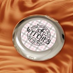 Pink Bad Witches Compact Travel Mirror, Pink and Brown Makeup Mirror, Cute & Shiny Mirror, Bad Witches Club Compact.  Pink Bad Witches Travel Mirror is a stylish and compact makeup gadget for touching up on the go. With a glossy finish, secure snap closure, and customizable design, this mirror is perfect for those who love a touch of whimsy in their beauty routine. Ideal for travelers, makeup enthusiasts, and those who appreciate unique accessories. Relevant for Halloween, witch-themed events, or as a fun gift for a friend. Product features - Glossy surface with metallic insert - Slim form for easy portability - Secure snap friction closure - Metal case with dual glass mirrors - Customizable white metal insert Care instructions - Wipe the dust or any dirt off gently with a clean, dry cloth Pink And Brown Makeup, Compact Makeup, Travel Mirror, Brown Makeup, The Worst Witch, Unique Accessories, Themed Events, Pink And Brown, Home Decor Mirrors