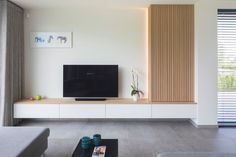 a flat screen tv sitting on top of a white entertainment center in a living room