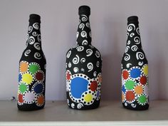 three bottles are sitting on a shelf with different designs painted on them and one is black, the other has multicolored circles